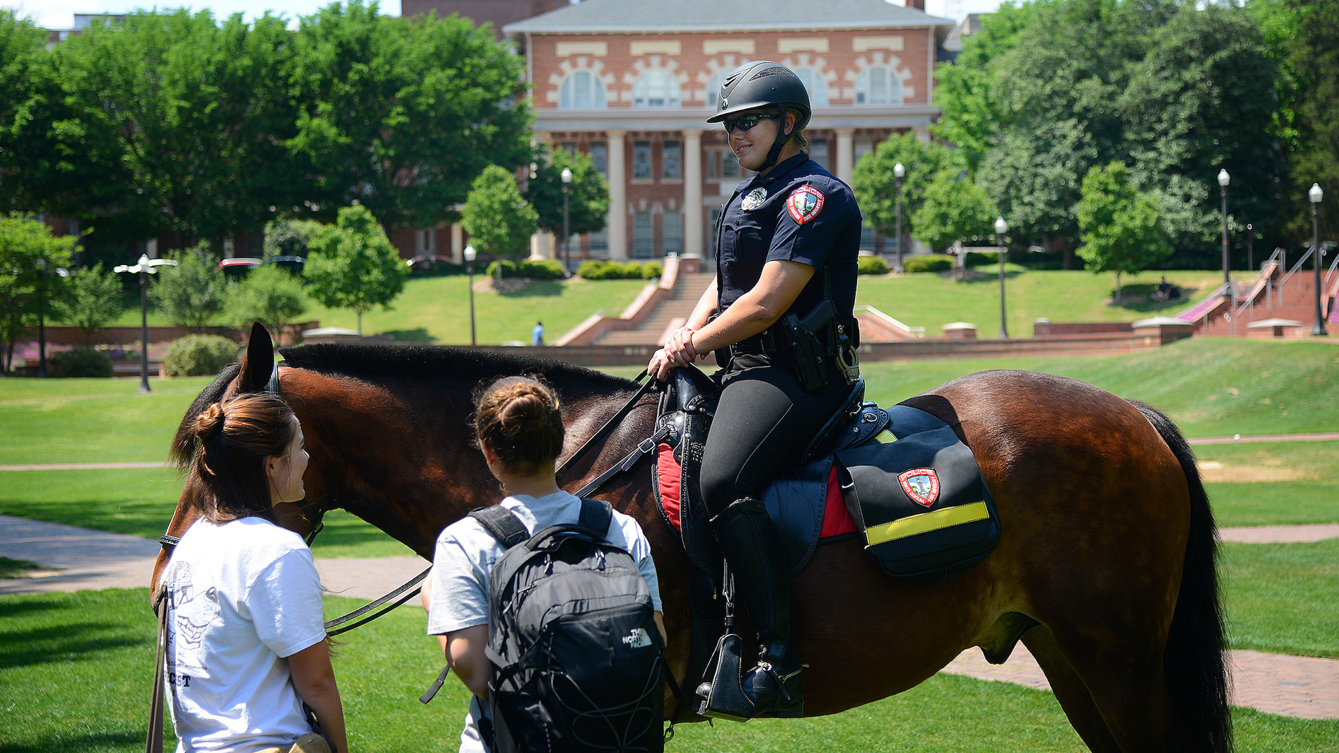 A University Police officer on horseback speaks to NC States on the Court of North Carolina.